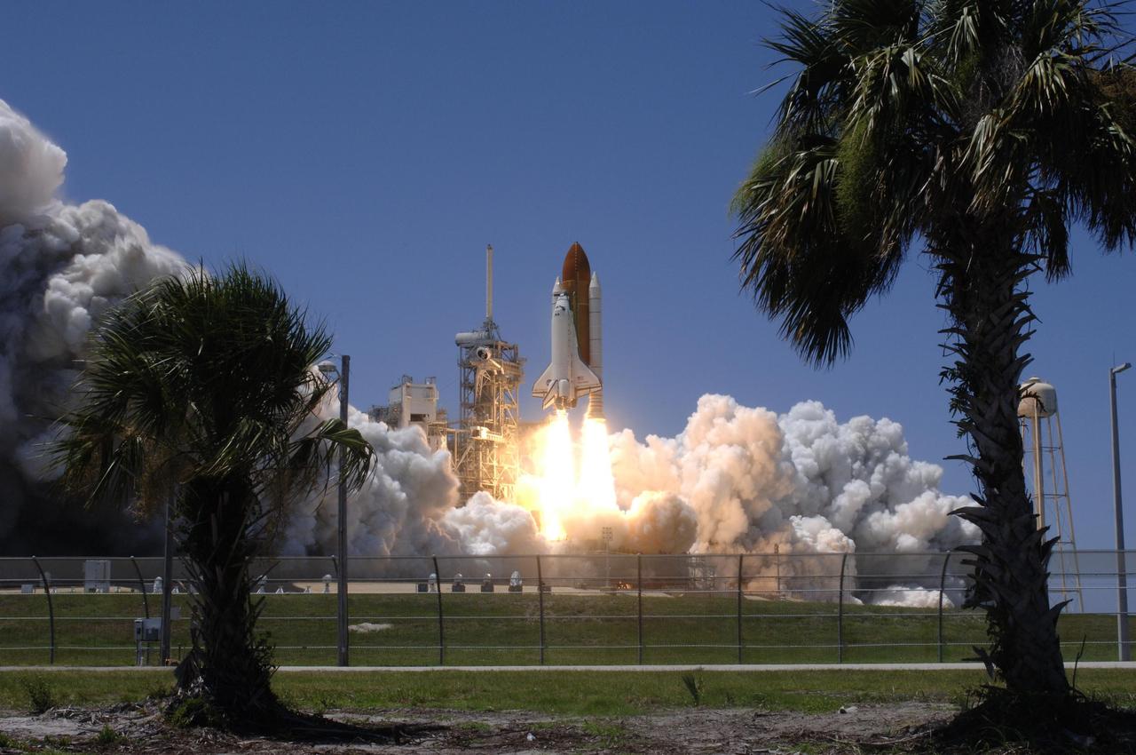 KENNEDY SPACE CENTER, FLA. - Framed by palm trees, Space Shuttle Discovery lifts off Launch Pad 39B at 2:38 p.m. EDT. The fiery display fit the day: Fourth of July. The launch made history as it was the first ever launch on Independence Day. During the 12-day mission, the STS-121 crew of seven will test new equipment and procedures to improve shuttle safety, as well as deliver supplies and make repairs to the International Space Station. Landing is scheduled for July 16 or 17 at Kennedy's Shuttle Landing Facility. Photo credit: NASA/Sandy Joseph, Robert Murray