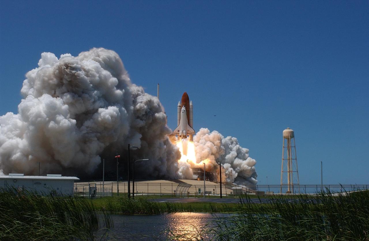 KENNEDY SPACE CENTER, FLA. - From the west side of Launch Pad 39B, Space Shuttle Discovery is viewed moments after liftoff on mission STS-121. The fiery display fit the day: Fourth of July. The launch made history as it was the first ever to take place on Independence Day. During the 12-day mission, the STS-121 crew of seven will test new equipment and procedures to improve shuttle safety, as well as deliver supplies and make repairs to the International Space Station. Landing is scheduled for July 16 or 17 at Kennedy's Shuttle Landing Facility. Photo credit: NASA/Sandy Joseph, Robert Murray