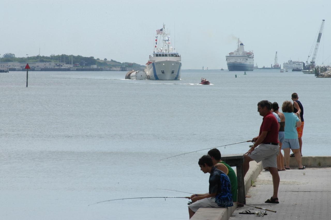 KENNEDY SPACE CENTER, FLA. - The SRB Retrieval Ship Liberty Star begins the rest of its journey to Cape Canaveral Air Force Station with a spent solid rocket booster alongside. The booster is from Space Shuttle Discovery, which launched on July 4. The space shuttle’s solid rocket booster casings and associated flight hardware are recovered at sea. The boosters impact the Atlantic Ocean approximately seven minutes after liftoff. The splashdown area is a square of about 6 by 9 nautical miles located about 140 nautical miles downrange from the launch pad. The retrieval ships are stationed approximately 8 to 10 nautical miles from the impact area at the time of splashdown. As soon as the boosters enter the water, the ships accelerate to a speed of 15 knots and quickly close on the boosters. The pilot chutes and main parachutes are the first items to be brought on board. With the chutes and frustum recovered, attention turns to the boosters. The ship’s tow line is connected and the booster is returned to the Port and ,after transfer to a position alongside the ship, to Hangar AF at Cape Canaveral Air Force Station. There, the expended boosters are disassembled, refurbished and reloaded with solid propellant for reuse. Photo credit: NASA/George Shelton