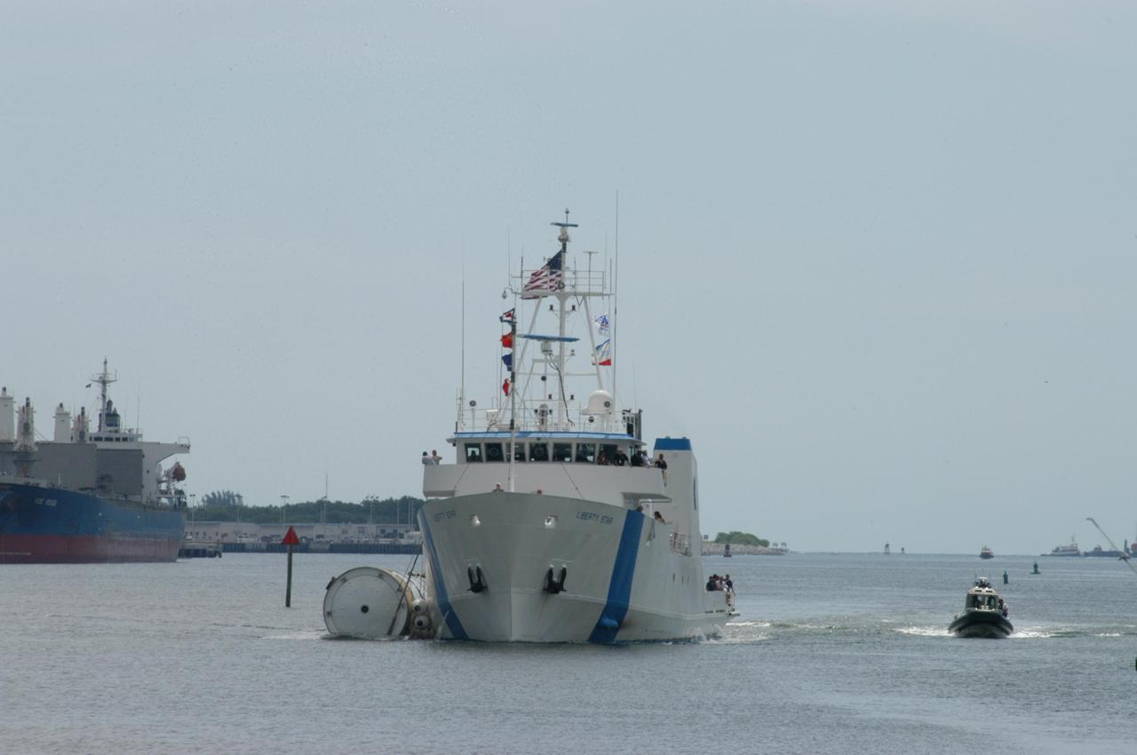 KENNEDY SPACE CENTER, FLA. - The SRB Retrieval Ship Liberty Star begins the rest of its journey to Cape Canaveral Air Force Station with a spent solid rocket booster alongside. The booster is from Space Shuttle Discovery, which launched on July 4. The space shuttle’s solid rocket booster casings and associated flight hardware are recovered at sea. The boosters impact the Atlantic Ocean approximately seven minutes after liftoff. The splashdown area is a square of about 6 by 9 nautical miles located about 140 nautical miles downrange from the launch pad. The retrieval ships are stationed approximately 8 to 10 nautical miles from the impact area at the time of splashdown. As soon as the boosters enter the water, the ships accelerate to a speed of 15 knots and quickly close on the boosters. The pilot chutes and main parachutes are the first items to be brought on board. With the chutes and frustum recovered, attention turns to the boosters. The ship’s tow line is connected and the booster is returned to the Port and ,after transfer to a position alongside the ship, to Hangar AF at Cape Canaveral Air Force Station. There, the expended boosters are disassembled, refurbished and reloaded with solid propellant for reuse. Photo credit: NASA/George Shelton