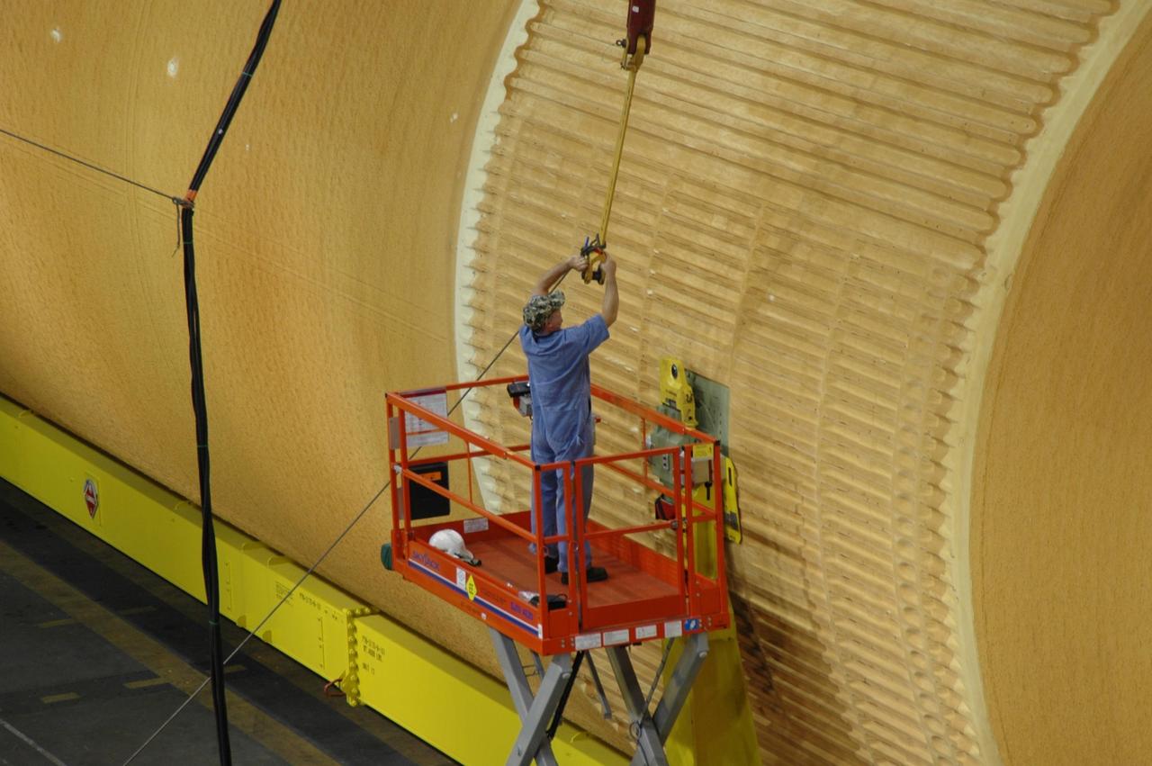 KENNEDY SPACE CENTER, FLA. -   A worker in the Vehicle Assembly Building attaches a crane to external tank No. 118 in order to raise it vertical and lift it into high bay 3 for mating with solid rocket boosters stacked there.  The tank is designated to fly on mission STS-115 with Atlantis.  It will fly with many major safety changes, including the removal of the protuberance air load ramps. The mission will deliver the second port truss segment, the P3/P4 Truss, to attach to the first port truss segment, the P1 Truss, as well as deploy solar array set 2A and 4A.  Launch of Space Shuttle Atlantis is scheduled for late August. Photo credit: NASA/Jim Grossmann