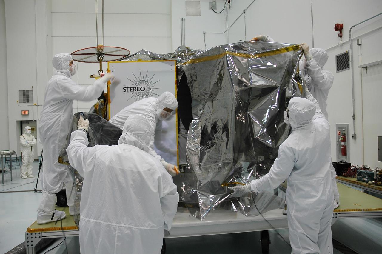 KENNEDY SPACE CENTER, FLA. - In the hazardous processing facility at Astrotech Space Operations in Titusville, Fla., technicians begin removing the protective cover from Observatory A of the STEREO spacecraft. The observatory will be lifted onto a scale for weight measurements and later will be fueled. STEREO stands for Solar Terrestrial Relations Observatory. The STEREO mission is the first to take measurements of the sun and solar wind in 3-dimension. This new view will improve our understanding of space weather and its impact on the Earth. STEREO is expected to lift off aboard a Boeing Delta II rocket no earlier than Aug. 1. Photo credit: NASA/Jack Pfaller