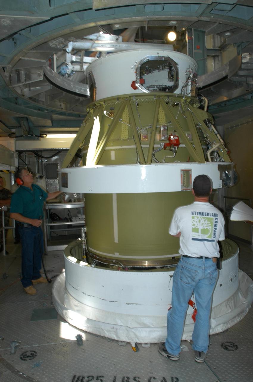 KENNEDY SPACE CENTER, FLA. - Inside the mobile service tower on Launch Pad 17-B on Cape Canaveral Air Force Station, workers stand by as the Boeing Delta II second stage for the STEREO launch is lowered onto the first stage for mating. STEREO stands for Solar Terrestrial Relations Observatory and comprises two spacecraft. The STEREO mission is the first to take measurements of the sun and solar wind in 3-dimension. This new view will improve our understanding of space weather and its impact on the Earth. STEREO is expected to lift off in August 2006. Photo credit: NASA/George Shelton