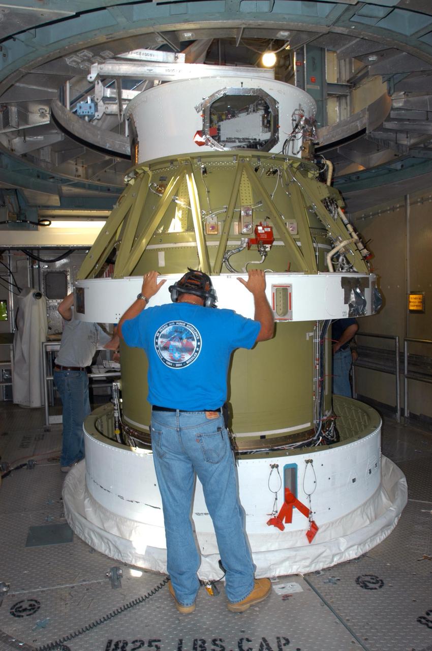 KENNEDY SPACE CENTER, FLA. - Inside the mobile service tower on Launch Pad 17-B on Cape Canaveral Air Force Station, workers help guide the Boeing Delta II second stage for the STEREO launch onto the first stage for mating. STEREO stands for Solar Terrestrial Relations Observatory and comprises two spacecraft. The STEREO mission is the first to take measurements of the sun and solar wind in 3-dimension. This new view will improve our understanding of space weather and its impact on the Earth. STEREO is expected to lift off in August 2006. Photo credit: NASA/George Shelton