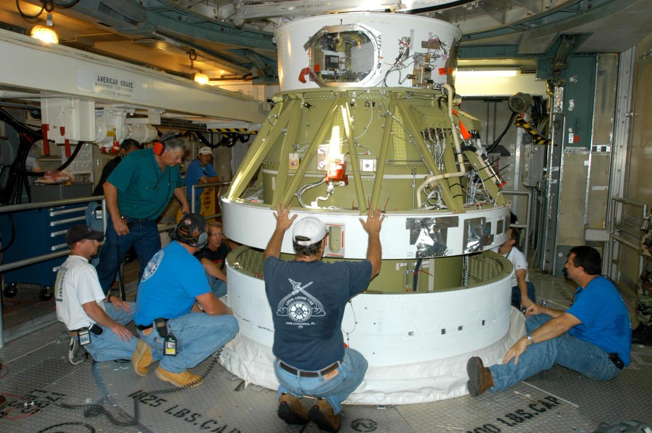 KENNEDY SPACE CENTER, FLA. - Inside the mobile service tower on Launch Pad 17-B on Cape Canaveral Air Force Station, workers help guide the Boeing Delta II second stage for the STEREO launch onto the first stage for mating. STEREO stands for Solar Terrestrial Relations Observatory and comprises two spacecraft. The STEREO mission is the first to take measurements of the sun and solar wind in 3-dimension. This new view will improve our understanding of space weather and its impact on the Earth. STEREO is expected to lift off in August 2006. Photo credit: NASA/George Shelton