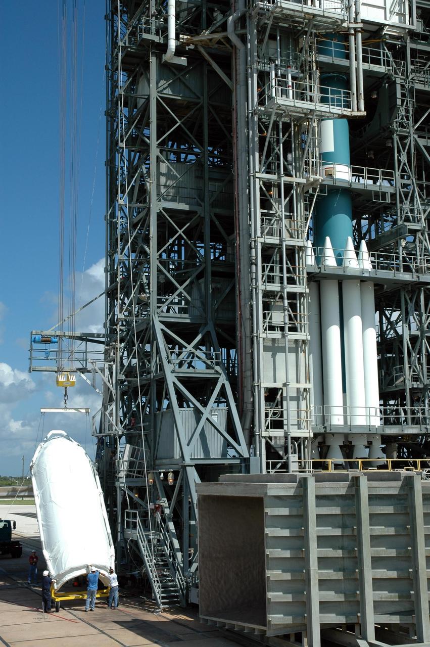 KENNEDY SPACE CENTER, FLA. - Shrouded with a protective cover, half of the payload fairing for the STEREO spacecraft is raised off its transporter on Launch Pad 17-B at Cape Canaveral Air Force Station in Florida. The payload fairing will be lifted into the clean room in the mobile service tower and later installed around the spacecraft for protection during launch. The fairing is a molded structure that fits flush with the outside surface of the Delta II upper stage booster and forms an aerodynamically smooth nose cone, protecting the spacecraft during launch and ascent. STEREO, which stands for Solar Terrestrial Relations Observatory, comprises two spacecraft. The STEREO mission is the first to take measurements of the sun and solar wind in 3-dimension. This new view will improve our understanding of space weather and its impact on the Earth. STEREO is expected to lift off aboard a Boeing Delta II rocket in August 2006. Photo credit: NASA/Jim Grossmann