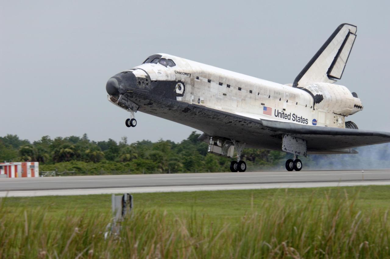 KENNEDY SPACE CENTER, FLA. - The orbiter Discovery touches down on Runway 15 at NASA's Shuttle Landing Facility after completing mission STS-121 to the International Space Station. Discovery traveled 5.3 million miles, landing on orbit 202. Mission elapsed time was 12 days, 18 hours, 37 minutes and 54 seconds. Main gear touchdown occurred on time at 9:14:43 EDT. Wheel stop was at 9:15:49 EDT. The returning crew members aboard are Commander Steven Lindsey, Pilot Mark Kelly and Mission Specialists Piers Sellers, Michael Fossum, Lisa Nowak and Stephanie Wilson. Mission Specialist Thomas Reiter, who launched with the crew on July 4, remained on the station to join the Expedition 13 crew there. The landing is the 62nd at Kennedy Space Center and the 32nd for Discovery. Discovery's landing was as exhilarating as its launch, the first to take place on America's Independence Day. During the mission, the STS-121 crew tested new equipment and procedures to improve shuttle safety, and delivered supplies and made repairs to the International Space Station. Photo credit: NASA/Tim Powers