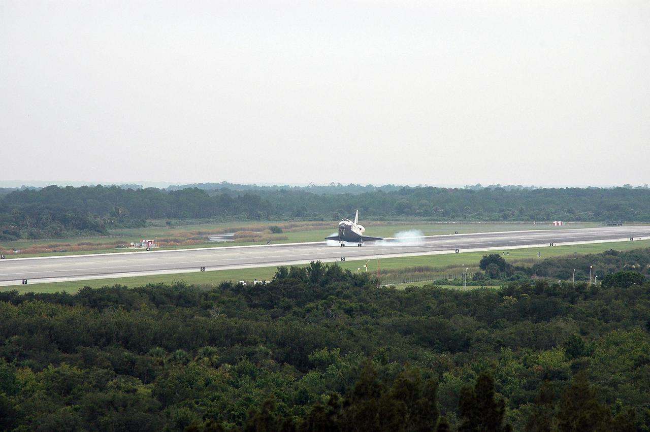 KENNEDY SPACE CENTER, FLA. - Under gray skies blanketing the Central Florida skies, the orbiter Discovery kicks up dust as it touches down on Runway 15 at NASA's Shuttle Landing Facility after completing mission STS-121 to the International Space Station. Discovery traveled 5.3 million miles, landing on orbit 202. Mission elapsed time was 12 days, 18 hours, 37 minutes and 54 seconds. Main gear touchdown occurred on time at 9:14:43 EDT. Wheel stop was at 9:15:49 EDT. The returning crew members aboard are Commander Steven Lindsey, Pilot Mark Kelly and Mission Specialists Piers Sellers, Michael Fossum, Lisa Nowak and Stephanie Wilson. Mission Specialist Thomas Reiter, who launched with the crew on July 4, remained on the station to join the Expedition 13 crew there. The landing is the 62nd at Kennedy Space Center and the 32nd for Discovery. Discovery's landing was as exhilarating as its launch, the first to take place on America's Independence Day. During the mission, the STS-121 crew tested new equipment and procedures to improve shuttle safety, and delivered supplies and made repairs to the International Space Station. Photo credit: NASA/Kim Shiflett