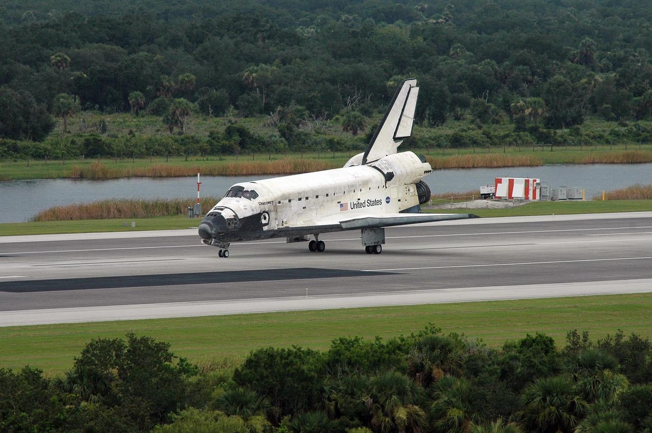 KENNEDY SPACE CENTER, FLA. - The orbiter Discovery slows to a stop after landing on Runway 15 at NASA's Shuttle Landing Facility, completing mission STS-121 to the International Space Station. Discovery traveled 5.3 million miles, landing on orbit 202. Mission elapsed time was 12 days, 18 hours, 37 minutes and 54 seconds. Main gear touchdown occurred on time at 9:14:43 EDT. Wheel stop was at 9:15:49 EDT. The returning crew members aboard are Commander Steven Lindsey, Pilot Mark Kelly and Mission Specialists Piers Sellers, Michael Fossum, Lisa Nowak and Stephanie Wilson. Mission Specialist Thomas Reiter, who launched with the crew on July 4, remained on the station to join the Expedition 13 crew there. The landing is the 62nd at Kennedy Space Center and the 32nd for Discovery. Discovery's landing was as exhilarating as its launch, the first to take place on America's Independence Day. During the mission, the STS-121 crew tested new equipment and procedures to improve shuttle safety, and delivered supplies and made repairs to the International Space Station. Photo credit: NASA/Kim Shiflett