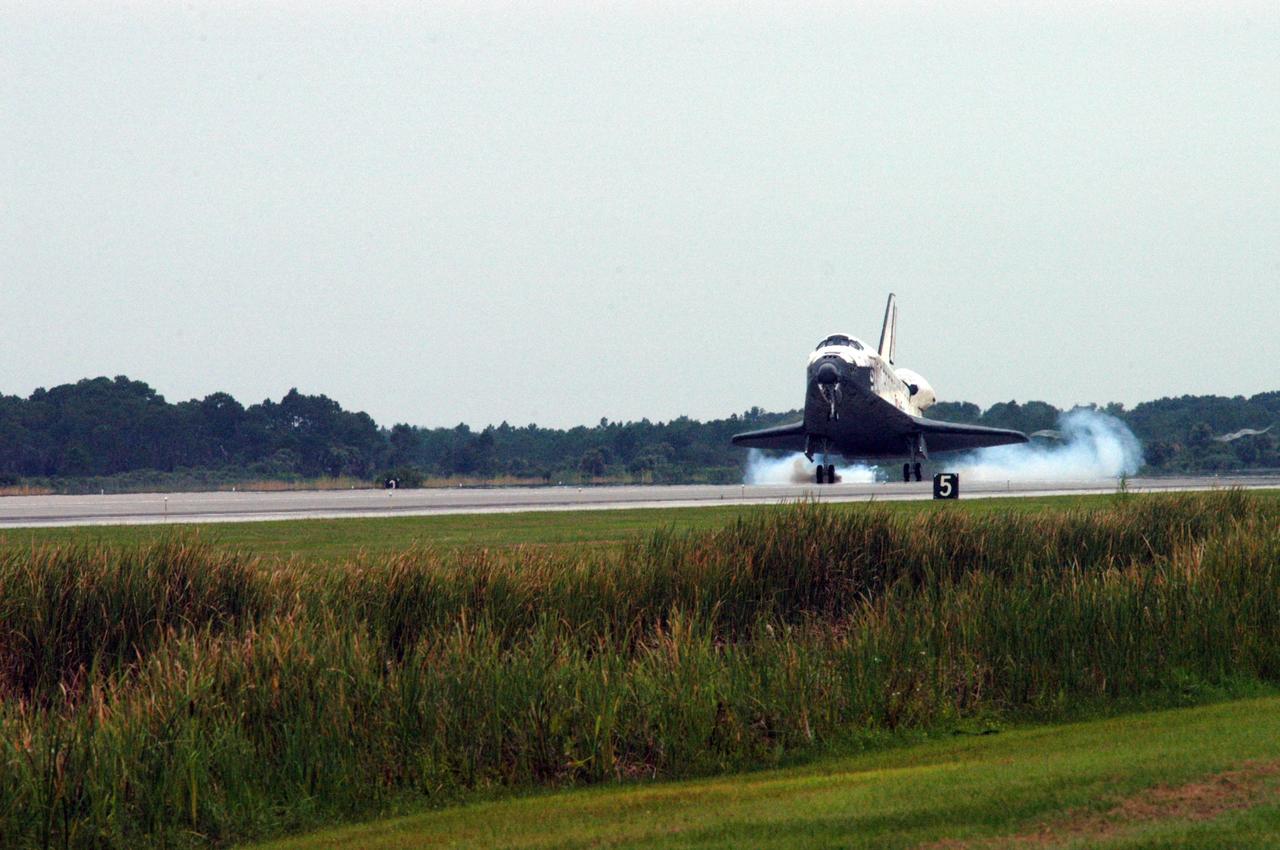 KENNEDY SPACE CENTER, FLA. - Kicking up dust as its wheels touch down, the orbiter Discovery lands on Runway 15 at NASA's Shuttle Landing Facility, completing mission STS-121 to the International Space Station. Discovery traveled 5.3 million miles, landing on orbit 202. Mission elapsed time was 12 days, 18 hours, 37 minutes and 54 seconds. Main gear touchdown occurred on time at 9:14:43 EDT. Wheel stop was at 9:15:49 EDT. The returning crew members aboard are Commander Steven Lindsey, Pilot Mark Kelly and Mission Specialists Piers Sellers, Michael Fossum, Lisa Nowak and Stephanie Wilson. Mission Specialist Thomas Reiter, who launched with the crew on July 4, remained on the station to join the Expedition 13 crew there. The landing is the 62nd at Kennedy Space Center and the 32nd for Discovery. Discovery's landing was as exhilarating as its launch, the first to take place on America's Independence Day. During the mission, the STS-121 crew tested new equipment and procedures to improve shuttle safety, and delivered supplies and made repairs to the International Space Station. Photo credit: NASA/George Shelton