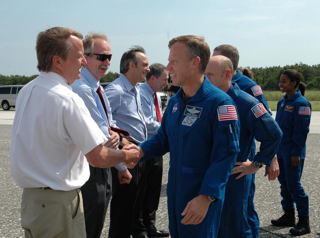 KENNEDY SPACE CENTER, FLA. - (From left) Shuttle Launch Director Mike Leinbach, Associate Administrator for Space Operations Bill Gerstenmaier, Associate Administrator Rex Geveden and NASA Administrator Mike Griffin greet STS-121 Commander Steven Lindsey, Pilot Mike Kelly and Mission Specialists Michael Fossum and Stephanie Wilson. Not visible are Mission Specialists Piers Sellers and Lisa Nowak. Mission Specialist Thomas Reiter, who launched with the crew on July 4, remained on the station to join the Expedition 13 crew there. Discovery's smooth and perfect landing was on time at 9:14 a.m. EDT on Runway 15 of NASA's Shuttle Landing Facility after traveling 5.3 million miles on 202 orbits. Mission elapsed time was 12 days, 18 hours, 37 minutes and 54 seconds. The landing is the 62nd at Kennedy Space Center and the 32nd for Discovery. Photo credit: NASA/Kim Shiflett