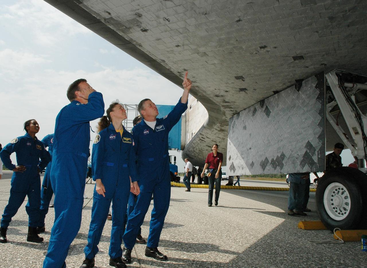 KENNEDY SPACE CENTER, FLA. -   The STS-121 crew gets a close look at the underside of the orbiter Discovery after landing.  Seen are (from left) Mission Specialist Stephanie Wilson, Commander Steven Lindsey and Mission Specialists Lisa Nowak and Michael Fossum.  The post-flight walk-around is a tradition. Discovery's smooth and perfect landing was on time at 9:14 a.m. EDT on Runway 15 of NASA's Shuttle Landing Facility after traveling 5.3 million miles on 202 orbits. Mission elapsed time was 12 days, 18 hours, 37 minutes and 54 seconds.  The landing is the 62nd at Kennedy Space Center and the 32nd for Discovery. Photo credit: NASA/Kim Shiflett