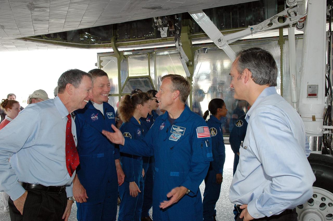 KENNEDY SPACE CENTER, FLA. -   NASA Administrator Mike Griffin talks with Commander Steven Lindsey (gesturing) after the crew looked over the orbiter Discovery, above them.  Between Griffin and Lindsey are Mission Specialists Michael Fossum and Lisa Nowak.  Mission Specialist Stephanie Wilson is behind Lindsey; Associate Administrator Rex Geveden is at right. The post-flight walk-around is a tradition.  Discovery's smooth and perfect landing was on time at 9:14 a.m. EDT on Runway 15 of NASA's Shuttle Landing Facility after traveling 5.3 million miles on 202 orbits. Mission elapsed time was 12 days, 18 hours, 37 minutes and 54 seconds.  The landing is the 62nd at Kennedy Space Center and the 32nd for Discovery. Photo credit: NASA/Kim Shiflett