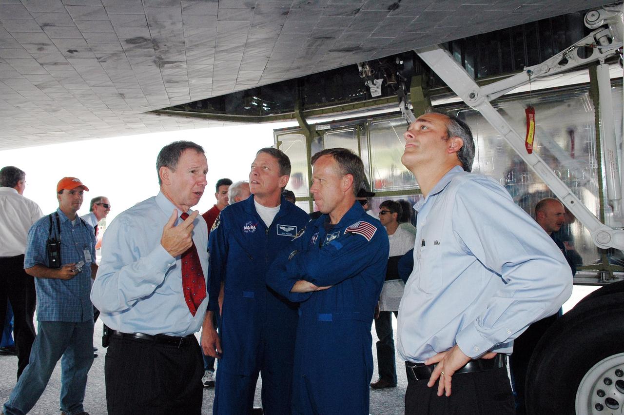 KENNEDY SPACE CENTER, FLA. -   During the traditional post-flight walk-around after the landing of an orbiter, crew members Michael Fossum, mission specialist, and Steven Lindsey, commander, talk with NASA Administrator Mike Griffin (left).  At right is Associate Administrator Rex Geveden.  Discovery's smooth and perfect landing was on time at 9:14 a.m. EDT on Runway 15 of NASA's Shuttle Landing Facility after traveling 5.3 million miles on 202 orbits. Mission elapsed time was 12 days, 18 hours, 37 minutes and 54 seconds.  The landing is the 62nd at Kennedy Space Center and the 32nd for Discovery. Photo credit: NASA/Kim Shiflett