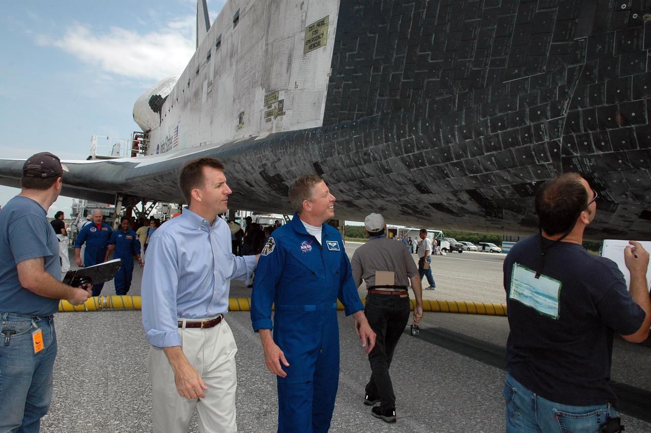 KENNEDY SPACE CENTER, FLA. -   LeRoy Cain, manager of Shuttle Launch Integration, and Michael Fossum, STS-121 mission specialist, take a look at the orbiter Discovery during the traditional post-flight walk-around after the landing.   Discovery's smooth and perfect landing was on time at 9:14 a.m. EDT on Runway 15 of NASA's Shuttle Landing Facility after traveling 5.3 million miles on 202 orbits. Mission elapsed time was 12 days, 18 hours, 37 minutes and 54 seconds.  The landing is the 62nd at Kennedy Space Center and the 32nd for Discovery. Photo credit: NASA/Kim Shiflett