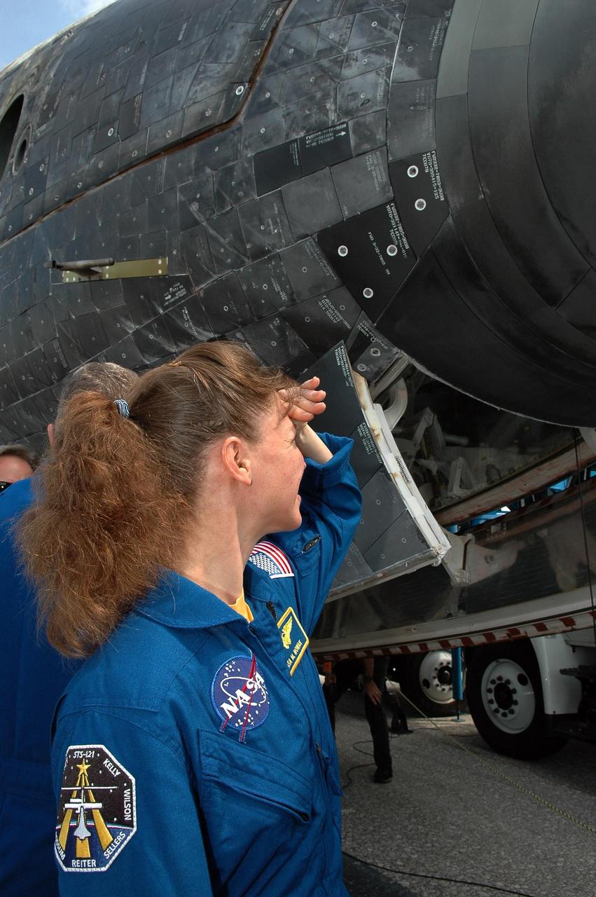 KENNEDY SPACE CENTER, FLA. -  During the traditional post-flight walk-around after the landing of an orbiter, Mission Specialist Lisa Nowak gets a close look at the nose cone.  Discovery's smooth and perfect landing was on time at 9:14 a.m. EDT on Runway 15 of NASA's Shuttle Landing Facility after traveling 5.3 million miles on 202 orbits. Mission elapsed time was 12 days, 18 hours, 37 minutes and 54 seconds.  The landing is the 62nd at Kennedy Space Center and the 32nd for Discovery. Photo credit: NASA/Kim Shiflett