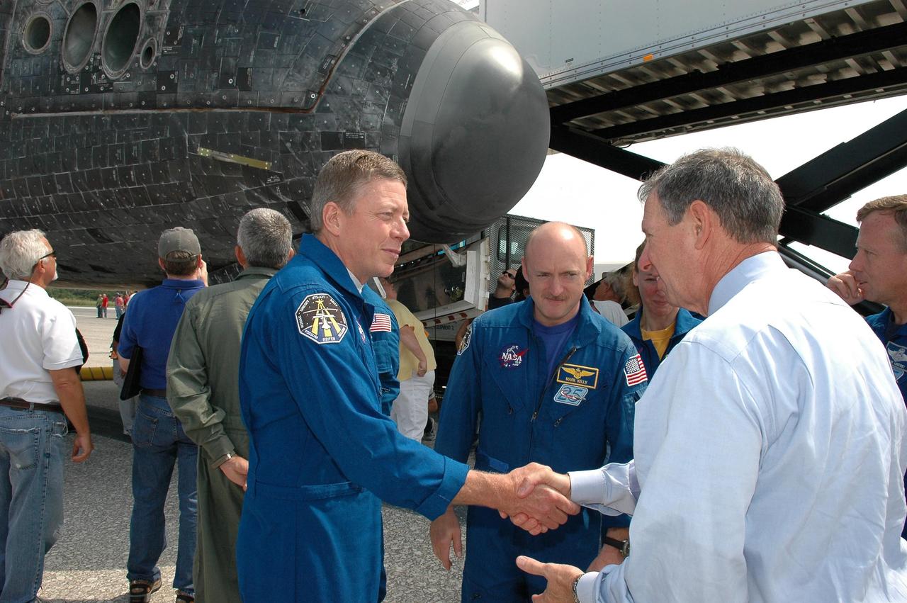 KENNEDY SPACE CENTER, FLA. -  During the traditional post-flight walk-around after the landing of an orbiter, NASA Administrator Mike Griffin (right) congratulates STS-121 Mission Specialist Michael Fossum on the successful mission.  Fossum participated in three spacewalks, along with Mission Specialist Piers Sellers, to repair and replace equipment.  Next to Fossum are Pilot Mark Kelly, Mission Specialist Lisa Nowak and (behind Griffin) Commander Steven Lindsey. Discovery's smooth and perfect landing was on time at 9:14 a.m. EDT on Runway 15 of NASA's Shuttle Landing Facility after traveling 5.3 million miles on 202 orbits. Mission elapsed time was 12 days, 18 hours, 37 minutes and 54 seconds.  The landing is the 62nd at Kennedy Space Center and the 32nd for Discovery. Photo credit: NASA/Kim Shiflett
