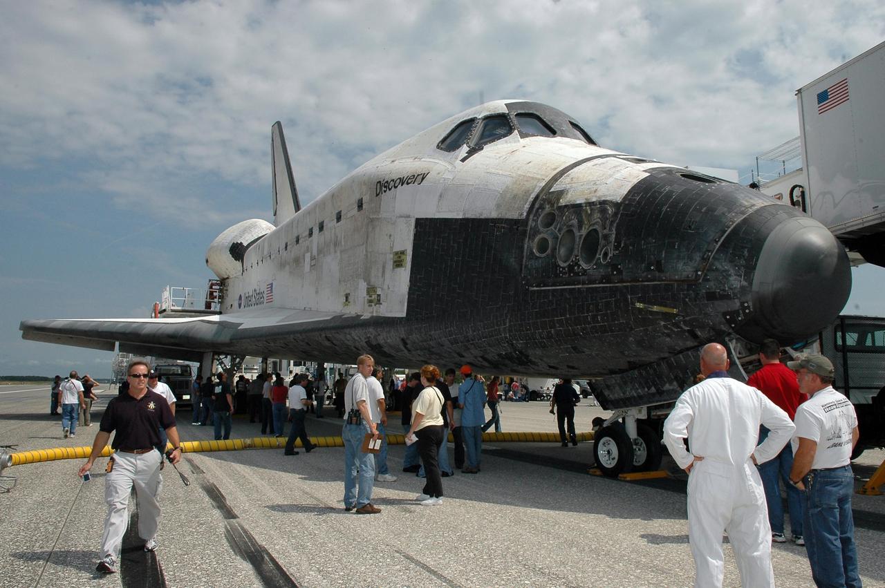 KENNEDY SPACE CENTER, FLA. -  Workers and media at NASA's Kennedy Space Center watch while the orbiter Discovery, following the landing from mission STS-121, is prepared for the roll to the Orbiter Processing Facility.  Discovery's smooth and perfect landing was on time at 9:14 a.m. EDT on Runway 15 of NASA's Shuttle Landing Facility after traveling 5.3 million miles on 202 orbits. Mission elapsed time was 12 days, 18 hours, 37 minutes and 54 seconds.  The landing is the 62nd at Kennedy Space Center and the 32nd for Discovery. Photo credit: NASA/Kim Shiflett