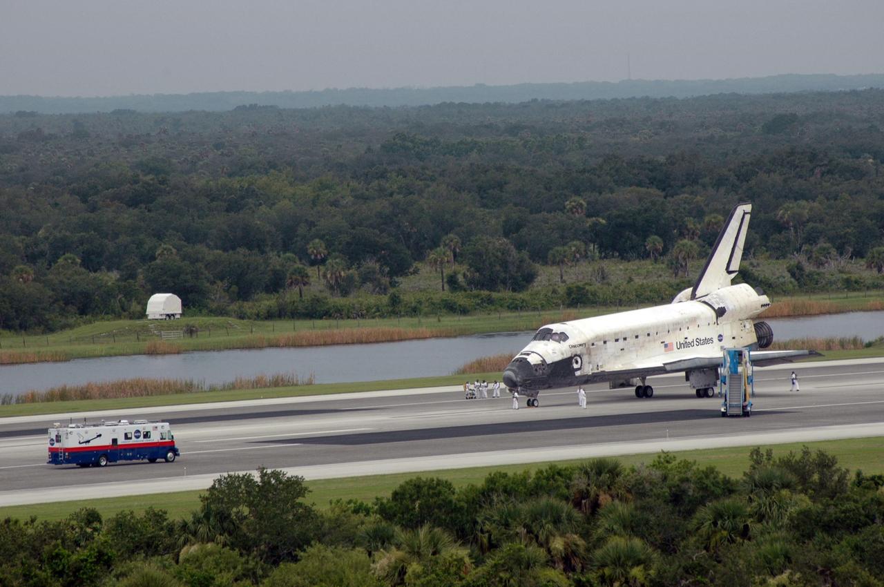 KENNEDY SPACE CENTER, FLA. -  A crew transport vehicle (CTV), a modified “people mover” used at airports, approaches the orbiter Discovery after the vehicle was "safed" for crew departure.  The crew exits the orbiter into a crew hatch access vehicle and, after a brief medical examination, transfers into the CTV.  Discovery's smooth and perfect landing after completing mission STS-121 was on time at 9:14 a.m. EDT on Runway 15 of NASA's Shuttle Landing Facility after traveling 5.3 million miles on 202 orbits. Mission elapsed time was 12 days, 18 hours, 37 minutes and 54 seconds.  The landing is the 62nd at Kennedy Space Center and the 32nd for Discovery. Photo credit: NASA/Kim Shiflett