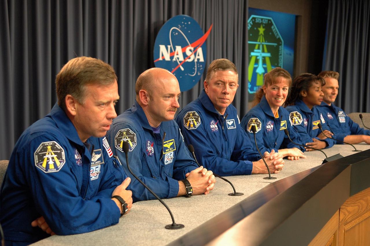 KENNEDY SPACE CENTER, FLA. -  Several hours after their successful landing at Kennedy Space Center aboard the orbiter Discovery, the crew of mission STS-121 address questions from the media about their experiences on the shuttle and the International Space Station. Seated at the conference table are (from left) Commander Steven Lindsey, Pilot Mark Kelly and Mission Specialists Michael Fossum, Lisa Nowak, Stephanie Wilson and Piers Sellers.  Discovery traveled  5.3 million miles, landing on orbit 202.  Mission elapsed time was 12 days, 18 hours, 37 minutes and 54 seconds.  During the nearly 13-day mission, the STS-121 crew tested new equipment and procedures to improve shuttle safety, and delivered supplies and made repairs to the International Space Station. Photo credit: NASA/Kim Shiflett