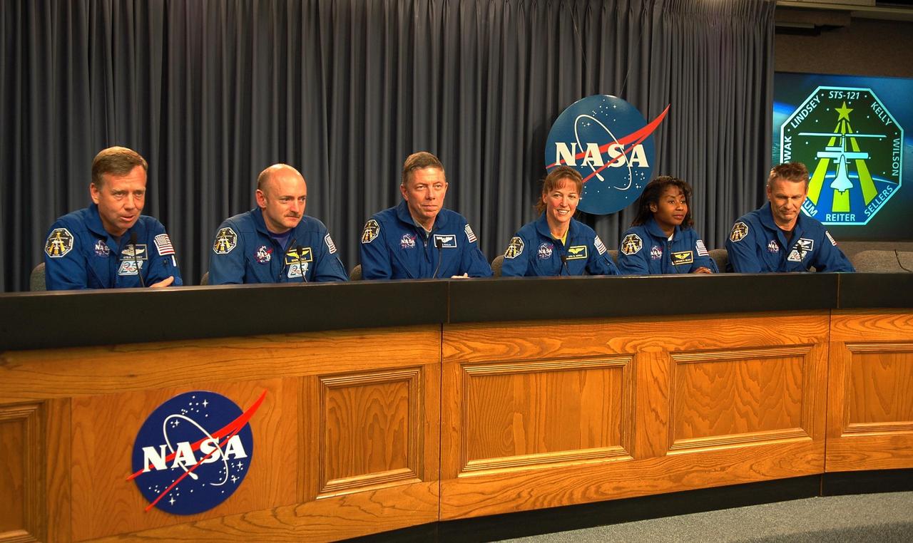 KENNEDY SPACE CENTER, FLA. -  Several hours after their successful landing at Kennedy Space Center aboard the orbiter Discovery, the crew of mission STS-121 address questions from the media about their experiences on the shuttle and the International Space Station. Seated at the conference table are (from left) Commander Steven Lindsey, Pilot Mark Kelly and Mission Specialists Michael Fossum, Lisa Nowak, Stephanie Wilson and Piers Sellers.  Discovery traveled  5.3 million miles, landing on orbit 202.  Mission elapsed time was 12 days, 18 hours, 37 minutes and 54 seconds.  During the nearly 13-day mission, the STS-121 crew tested new equipment and procedures to improve shuttle safety, and delivered supplies and made repairs to the International Space Station. Photo credit: NASA/Kim Shiflett