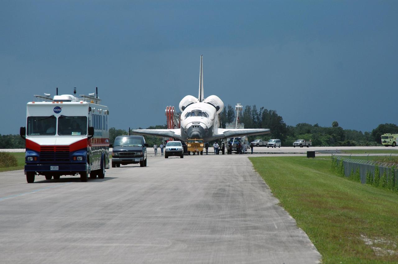 KENNEDY SPACE CENTER, FLA. -  Under tow by a diesel-powered tractor, the orbiter Discovery begins its roll to the Orbiter Processing Facility from NASA's Shuttle Landing Facility (SLF) at Kennedy Space Center via a two-mile tow-way.  Discovery landed at the SLF at 9:14 a.m. EDT, completing mission STS-121.  Discovery landed at the SLF at 9:14 a.m. EDT, completing mission STS-121. Discovery traveled  5.3 million miles, landing on orbit 202.  Mission elapsed time was 12 days, 18 hours, 37 minutes and 54 seconds.  Main gear touchdown occurred on time at 9:14:43 EDT.  Wheel stop was at 9:15:49 EDT. During the mission, the STS-121 crew tested new equipment and procedures to improve shuttle safety, and delivered supplies and made repairs to the International Space Station.  Photo credit: NASA/Jim Grossmann