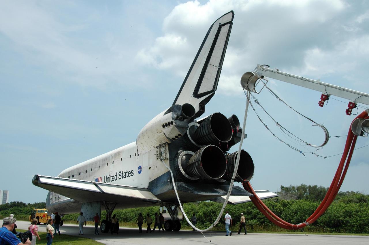 KENNEDY SPACE CENTER, FLA. -   Under tow by a diesel-powered tractor, the orbiter Discovery rolls to the Orbiter Processing Facility from NASA's Shuttle Landing Facility (SLF) via a two-mile tow-way. Umbilical lines for coolant and purge air are still attached.  Discovery landed at the SLF at 9:14 a.m. EDT, completing mission STS-121. Discovery traveled  5.3 million miles, landing on orbit 202.  Mission elapsed time was 12 days, 18 hours, 37 minutes and 54 seconds.  Main gear touchdown occurred on time at 9:14:43 EDT.  Wheel stop was at 9:15:49 EDT. During the mission, the STS-121 crew tested new equipment and procedures to improve shuttle safety, and delivered supplies and made repairs to the International Space Station.  Photo credit: NASA/Jim Grossmann
