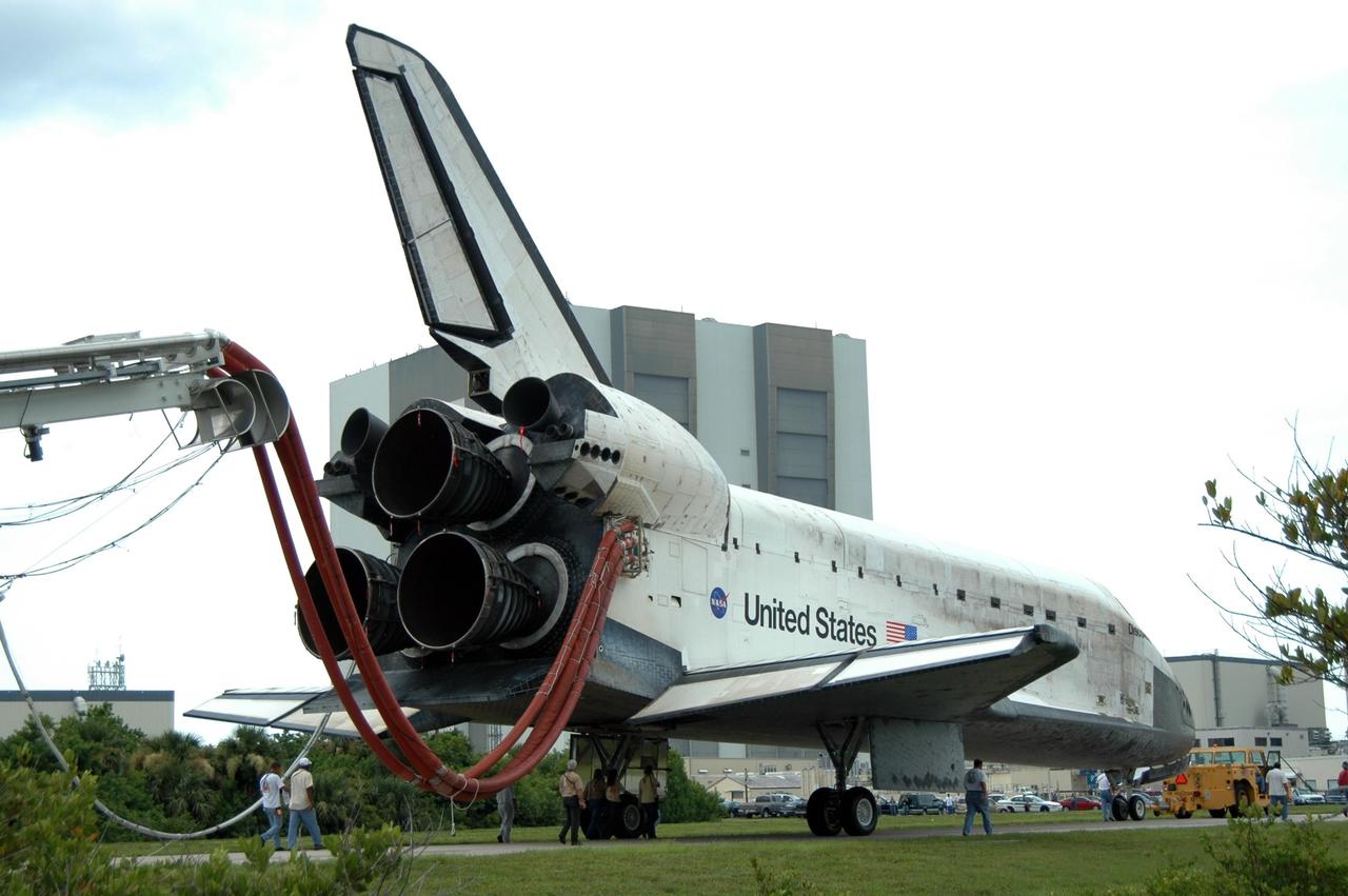 KENNEDY SPACE CENTER, FLA. -    Under tow by a diesel-powered tractor, the orbiter Discovery rolls past the Vehicle Assembly Building as it travels along the two-mile tow-way to the Orbiter Processing Facility from NASA's Shuttle Landing Facility. Umbilical lines for coolant and purge air are still attached. Discovery landed at the SLF at 9:14 a.m. EDT, completing mission STS-121.  Discovery traveled  5.3 million miles, landing on orbit 202.  Mission elapsed time was 12 days, 18 hours, 37 minutes and 54 seconds.  Main gear touchdown occurred on time at 9:14:43 EDT.  Wheel stop was at 9:15:49 EDT. During the mission, the STS-121 crew tested new equipment and procedures to improve shuttle safety, and delivered supplies and made repairs to the International Space Station.  Photo credit: NASA/Jim Grossmann