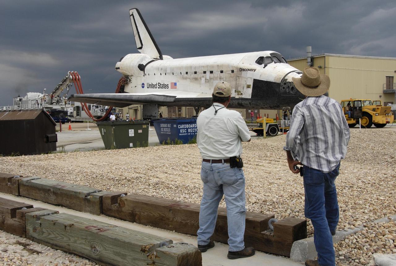 KENNEDY SPACE CENTER, FLA. -   On a two-mile tow from NASA's Shuttle Landing Facility, the orbiter Discovery rolls to the Orbiter Processing Facility.  Umbilical lines for coolant and purge air are still attached.  Discovery landed at the SLF at 9:14 a.m. EDT, completing mission STS-121.  Discovery traveled  5.3 million miles, landing on orbit 202.  Mission elapsed time was 12 days, 18 hours, 37 minutes and 54 seconds.  Main gear touchdown occurred on time at 9:14:43 EDT.  Wheel stop was at 9:15:49 EDT. During the mission, the STS-121 crew tested new equipment and procedures to improve shuttle safety, and delivered supplies and made repairs to the International Space Station.  Photo courtesy of Nikon/Scott Andrews