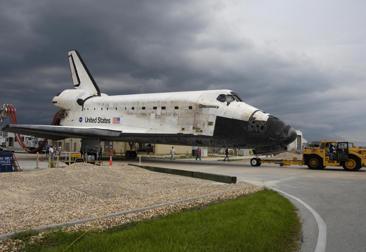 KENNEDY SPACE CENTER, FLA. -   On a two-mile tow from NASA's Shuttle Landing Facility, the orbiter Discovery rolls toward the Orbiter Processing Facility.  Umbilical lines for coolant and purge air are still attached.  Discovery landed at the SLF at 9:14 a.m. EDT, completing mission STS-121.  Discovery traveled  5.3 million miles, landing on orbit 202.  Mission elapsed time was 12 days, 18 hours, 37 minutes and 54 seconds.  Main gear touchdown occurred on time at 9:14:43 EDT.  Wheel stop was at 9:15:49 EDT. During the mission, the STS-121 crew tested new equipment and procedures to improve shuttle safety, and delivered supplies and made repairs to the International Space Station.  Photo courtesy of Nikon/Scott Andrews