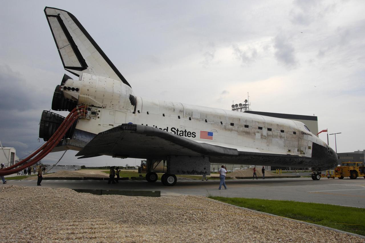KENNEDY SPACE CENTER, FLA. -   On a two-mile tow from NASA's Shuttle Landing Facility, the orbiter Discovery rolls toward the Orbiter Processing Facility.  Umbilical lines for coolant and purge air are still attached.  Discovery landed at the SLF at 9:14 a.m. EDT, completing mission STS-121.  Discovery traveled  5.3 million miles, landing on orbit 202.  Mission elapsed time was 12 days, 18 hours, 37 minutes and 54 seconds.  Main gear touchdown occurred on time at 9:14:43 EDT.  Wheel stop was at 9:15:49 EDT. During the mission, the STS-121 crew tested new equipment and procedures to improve shuttle safety, and delivered supplies and made repairs to the International Space Station.  Photo courtesy of Nikon/Scott Andrews