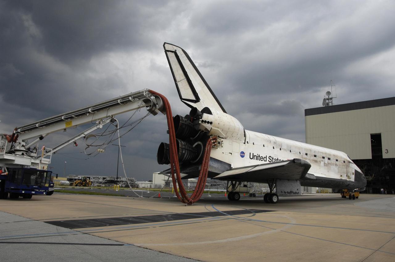 KENNEDY SPACE CENTER, FLA. -   As black clouds gather overhead, the orbiter Discovery arrives at the Orbiter Processing Facility after a two-mile tow from NASA's Shuttle Landing Facility. Umbilical lines for coolant and purge air are still attached.  Discovery landed at the SLF at 9:14 a.m. EDT, completing mission STS-121.  Discovery traveled  5.3 million miles, landing on orbit 202.  Mission elapsed time was 12 days, 18 hours, 37 minutes and 54 seconds.  Main gear touchdown occurred on time at 9:14:43 EDT.  Wheel stop was at 9:15:49 EDT. During the mission, the STS-121 crew tested new equipment and procedures to improve shuttle safety, and delivered supplies and made repairs to the International Space Station.  Photo courtesy of Nikon/Scott Andrews