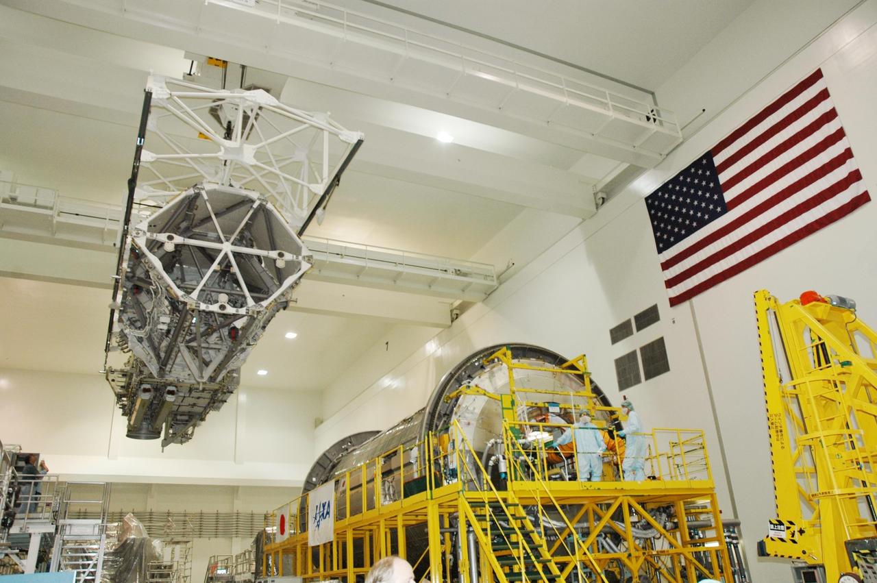 KENNEDY SPACE CENTER, FLA.  -   In the Space Station Processing Facility, an overhead crane moves the Port 3/4 truss segment across the floor to the waiting payload canister for installation in the orbiter Atlantis. The truss is slated for launch on mission STS-115 no earlier than Aug. 28. The truss is the next major addition to the 11-segment integrated truss structure that will eventually span more than 300 feet on the station. The P3/P4 truss, with its two large solar arrays, will provide one-fourth of the total power-generation capability of the completed station.  The P3/P4 truss is expected to be loaded into Atlantis's cargo bay around the beginning of August.  Photo credit: NASA/Troy Cryder