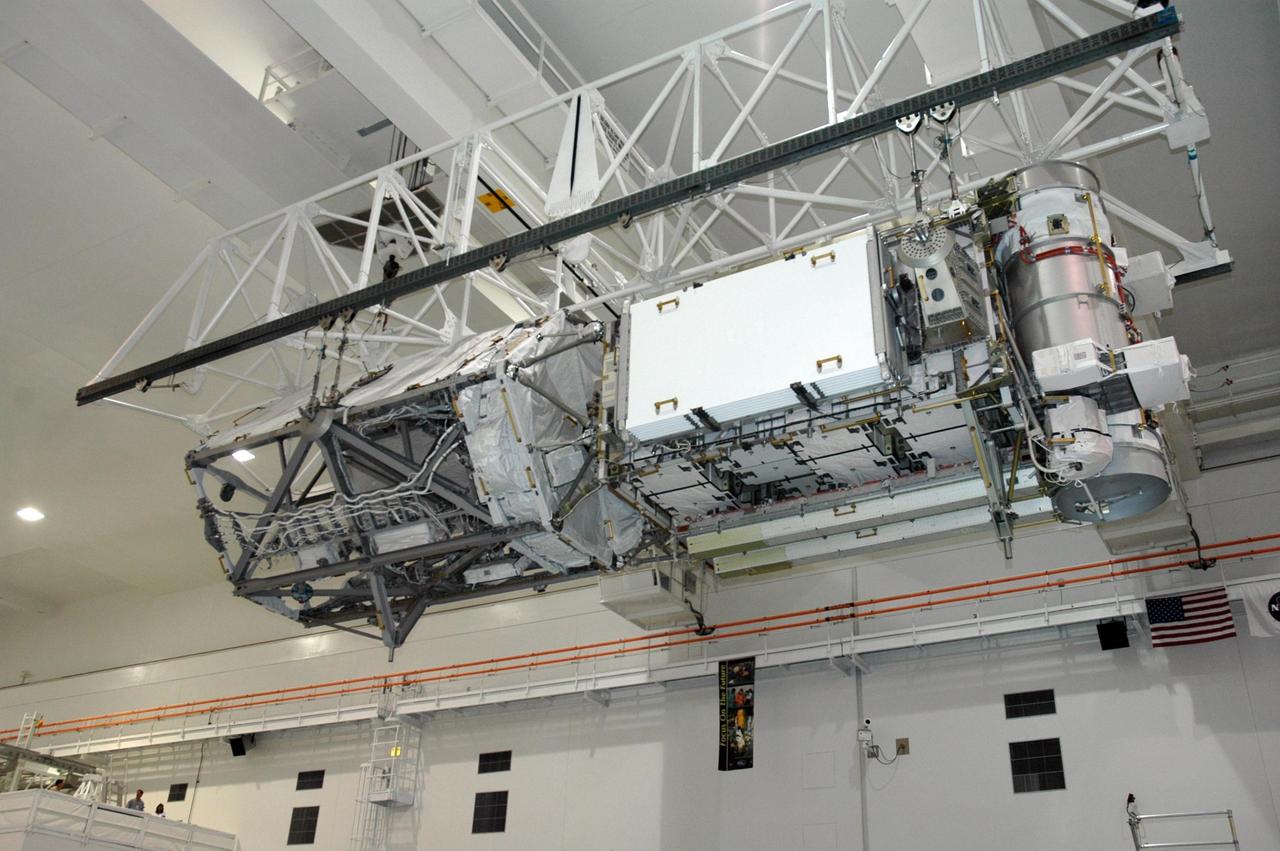 KENNEDY SPACE CENTER, FLA.  -   In the Space Station Processing Facility, an overhead crane lowers the Port 3/4 truss segment toward the waiting payload canister for installation in the orbiter Atlantis. On the right end are the mast canisters for the solar arrays. The truss is slated for launch on mission STS-115 no earlier than Aug. 28. The truss is the next major addition to the 11-segment integrated truss structure that will eventually span more than 300 feet on the station. The P3/P4 truss, with its two large solar arrays, will provide one-fourth of the total power-generation capability of the completed station.  The P3/P4 truss is expected to be loaded into Atlantis's cargo bay around the beginning of August.  Photo credit: NASA/Troy Cryder