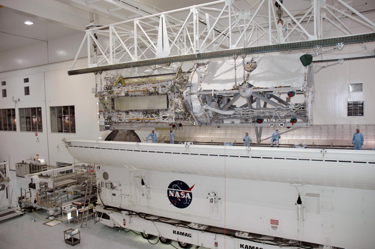 KENNEDY SPACE CENTER, FLA.  -    In the Space Station Processing Facility, an overhead crane lowers the Port 3/4 truss segment into the waiting payload canister for installation in the orbiter Atlantis.  The truss is slated for launch on mission STS-115 no earlier than Aug. 28. The truss is the next major addition to the 11-segment integrated truss structure that will eventually span more than 300 feet on the station. The P3/P4 truss, with its two large solar arrays, will provide one-fourth of the total power-generation capability of the completed station.  The P3/P4 truss is expected to be loaded into Atlantis's cargo bay around the beginning of August.  Photo credit: NASA/Troy Cryder