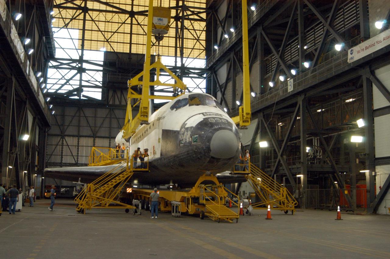KENNEDY SPACE CENTER, FLA.  -   In preparation for lifting Atlantis into high bay 3 of the Vehicle Assembly Building, workers are installing a large crane around it to raise it off the transporter into a vertical position.  After Atlantis is lifted and moved into the high bay, the orbiter will be lowered and mated with the external tank and solid rocket boosters already stacked on the mobile launcher platform.  Atlantis' launch window begins Aug. 28. During its 11-day mission to the International Space Station, the STS-115 crew of six astronauts will install the Port 3/4 truss segment with its two large solar arrays.   Photo credit: NASA/George Shelton