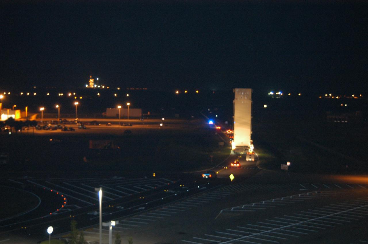 KENNEDY SPACE CENTER, FLA.  - Shortly after midnight, the payload canister and convoy negotiate the turn on the Saturn Causeway, heading for Launch Pad 39B.  Inside the canister is the payload for Atlantis and mission STS-115, the Port 3/4 truss segment with two large solar arrays. The payload changeout room provides an environmentally clean or "white room" condition in which to receive a payload transferred from a protective payload canister. After the shuttle arrives at the pad, the rotating service structure will close around it and the payload will then be transferred into Atlantis' payload bay.  Atlantis' launch window begins Aug. 28. During its 11-day mission to the International Space Station, the STS-115 crew of six astronauts will install  the truss, a 17-ton segment of the space station's truss backbone.  Photo credit: NASA/George Shelton