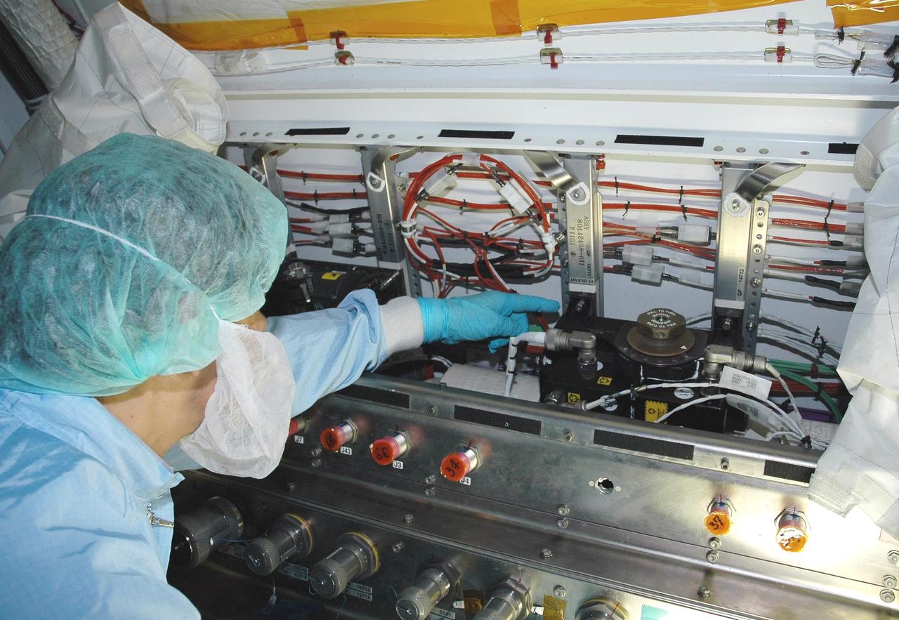 KENNEDY SPACE CENTER, FLA. - In the Space Station Processing Facility, Japan Aerospace Exploration Agency (JAXA) technicians inspect the wiring on the Japanese Experiment Module (JEM).  The JEM, developed by JAXA for use on the International Space Station, is named Kibo -- which means "hope" in Japanese -- and will enhance the unique research capabilities of the orbiting complex by providing an additional environment for astronauts to conduct science experiments.  Research conducted in Kibo will focus on space medicine, biology, Earth observations, material production, biotechnology and communications. Photo credit: NASA/Amanda Diller
