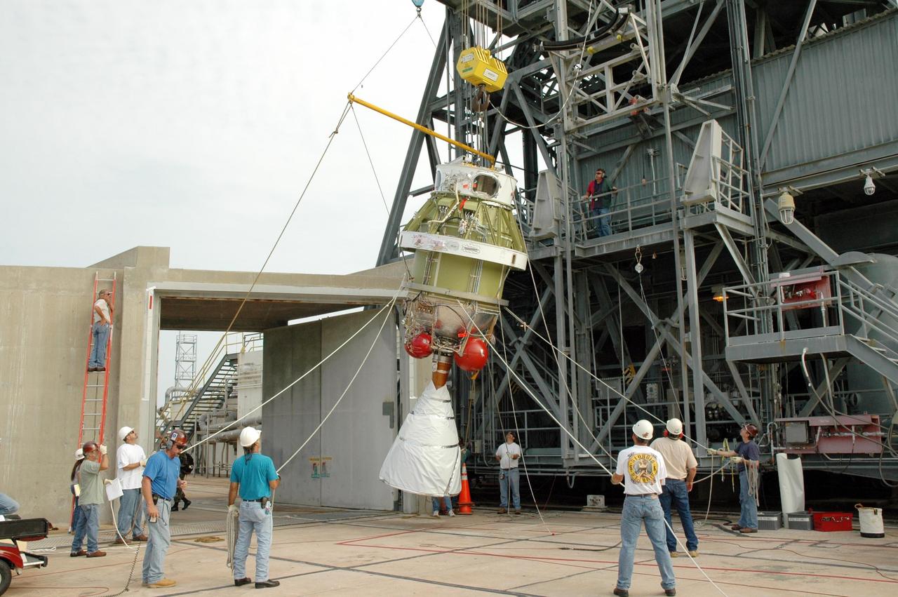 KENNEDY SPACE CENTER, FLA. - On Launch Pad 17-B at Cape Canaveral Air Force Station in Florida, workers maneuver the ropes tied to the second stage segment as it is being lowered to a horizontal position. It will be placed on a transporter and moved to the High-Pressure Test Facility for leak testing. The segment was destacked from the Delta II rocket in the mobile service tower. At the Boeing plant in Alabama, a leak was observed in the second-stage oxidizer tank for another Delta II that had been scheduled to launch in November; therefore, all identical tanks scheduled for launch in the near future are being checked. The second stage for the Delta II that will launch STEREO cannot be effectively tested while atop the first stage at Pad 17-B. STEREO stands for Solar Terrestrial Relations Observatory and comprises two spacecraft. The STEREO mission is the first to take measurements of the sun and solar wind in 3-dimension. This new view will improve our understanding of space weather and its impact on the Earth. STEREO is expected to lift off in late August 2006. Photo credit: NASA/Jim Grossmann