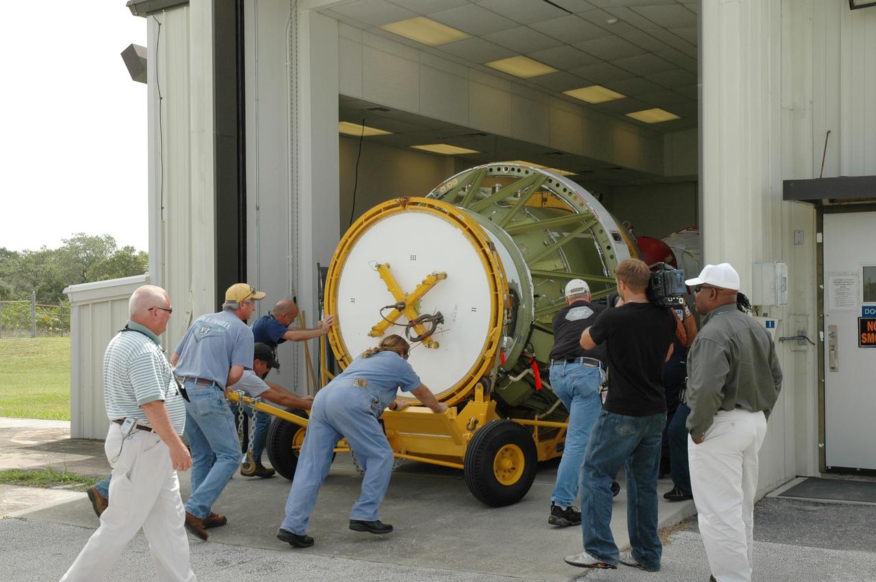 KENNEDY SPACE CENTER, FLA. - On Launch Pad 17-B at Cape Canaveral Air Force Station in Florida, workers maneuver the transporter carrying the second stage segment of a Delta II rocket into the High-Pressure Test Facility for leak testing. The segment was destacked from the Delta II rocket in the mobile service tower. At the Boeing plant in Alabama, a leak was observed in the second-stage oxidizer tank for another Delta II that had been scheduled to launch in November; therefore, all identical tanks scheduled for launch in the near future are being checked. The second stage for the Delta II that will launch STEREO cannot be effectively tested while atop the first stage at Pad 17-B. STEREO stands for Solar Terrestrial Relations Observatory and comprises two spacecraft. The STEREO mission is the first to take measurements of the sun and solar wind in 3-dimension. This new view will improve our understanding of space weather and its impact on the Earth. STEREO is expected to lift off in late August 2006. Photo credit: NASA/Jim Grossmann