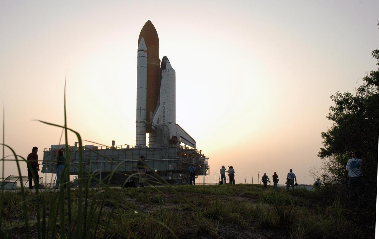 KENNEDY SPACE CENTER, FLA. -   In the early morning light, photographers maneuver for the best position to capture Space Shuttle Atlantis as it rolls toward Launch Pad 39B.  First motion out of the Vehicle Assembly Building was 1:05 a.m.  The shuttle sits on top of the mobile launcher platform, which in turn rests on the crawler-transporter.   The slow speed of the crawler results in a 6-hour trek to the pad approximately 4 miles away.  Atlantis' launch window begins Aug. 27 for an 11-day mission to the International Space Station. The STS-115 crew of six astronauts will continue construction of the station and install their cargo, the Port 3/4 truss segment with its two large solar arrays.   Photo credit: NASA/Troy Cryder