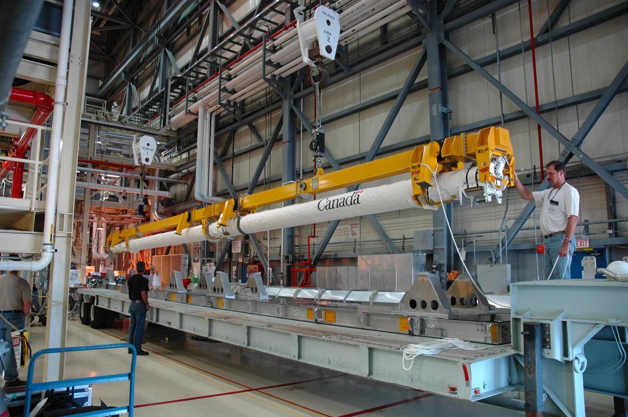 KENNEDY SPACE CENTER, FLA. - In bay 3 of the Orbiter Processing Facility, the orbiter boom sensor system (OBSS) is lifted off a stand. The boom will be reinstalled in Discovery's payload bay. It was removed last week in order to inspect the power system, which is routine after every flight. Discovery returned from mission STS-121 in late July, and is now being processed for mission STS-116, scheduled to launch in mid-December. Photo credit: NASA/Jim Grossmann