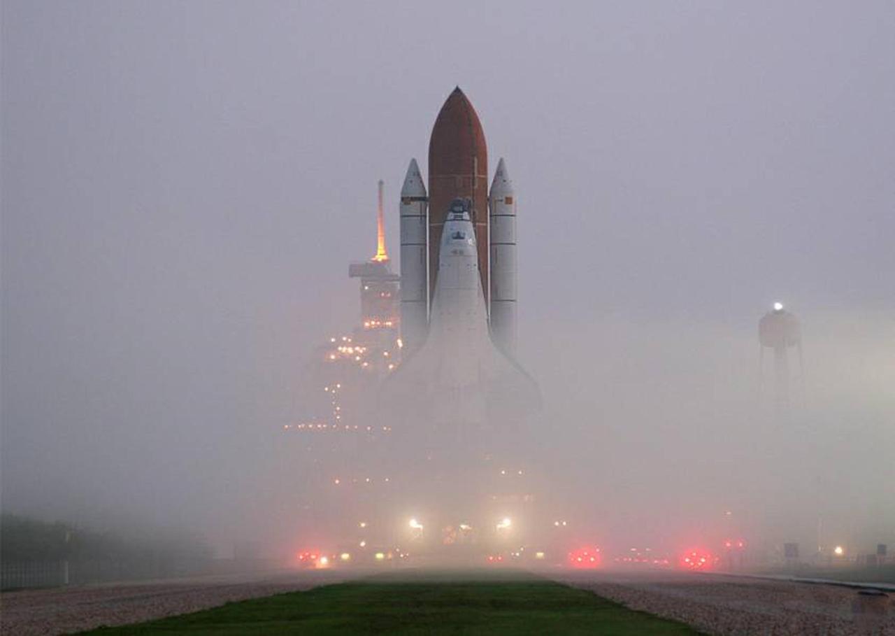 KENNEDY SPACE CENTER, FLA. -   Like a fantasy movie scene, the fog on Launch Pad 39B is pierced by lights on vehicles and the service structures as Space Shuttle Atlantis approaches.  Atlantis left the Vehicle Assembly Building 1:05 a.m. and arrived at the pad nearly 8 hours later.  Atlantis' launch window begins Aug. 27 for an 11-day mission, STS-115, to the International Space Station. The mission crew of six astronauts will continue construction of the station and install their cargo, the Port 3/4 truss segment with its two large solar arrays.   Photo credit: NASA/Rod Ostoski