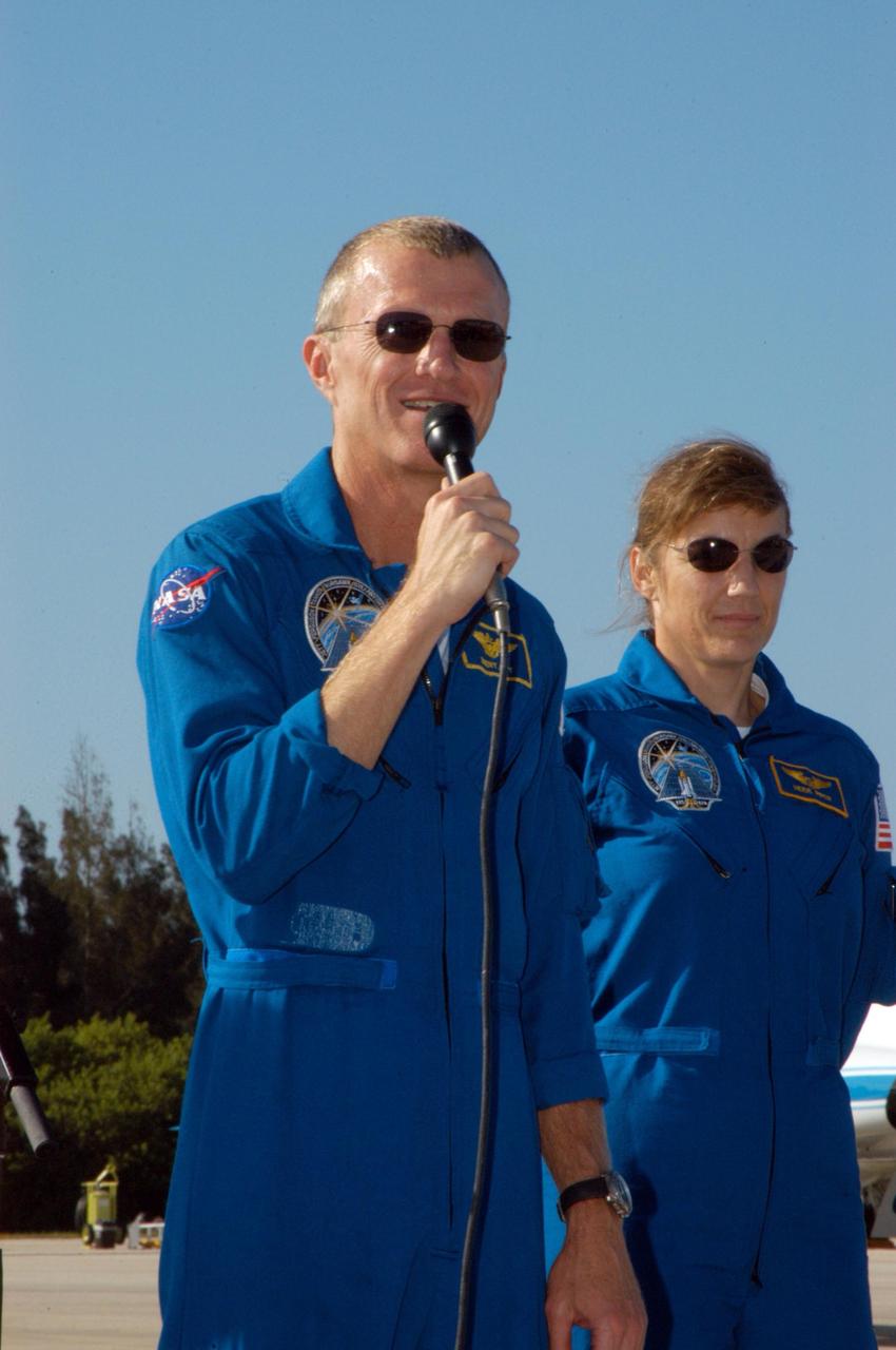 KENNEDY SPACE CENTER, FLA. - STS-115 Commander Brent Jett introduces his crew to waiting media at KSC's Shuttle Landing Facility after their arrival from Houston. At right is Mission Specialist Heidemarie Stefanyshyn-Piper. The STS-115 crew has flown to NASA's Kennedy Space Center to take part in Terminal Countdown Demonstration Test activities. The TCDT is a pre-launch preparation that includes practicing emergency egress from the pad, driving an M-113 armored personnel carrier, and simulating the launch countdown. Launch of STS-115 is currently scheduled for Aug. 27. Photo credit: NASA/George Shelton