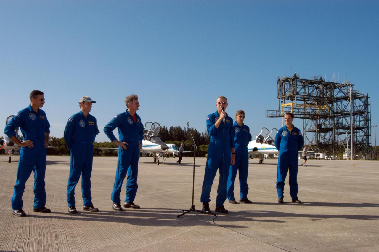 KENNEDY SPACE CENTER, FLA. - STS-115 Commander Brent Jett introduces his crew to waiting media at KSC's Shuttle Landing Facility after their arrival from Houston.  At left are Mission Specialists Daniel Burbank, Steven MacLean and Joseph Tanner; at right are Mission Specialist Heidemarie Stefanyshyn-Piper and Pilot Christopher Ferguson. The STS-115 crew has flown to NASA's Kennedy Space Center to take part in Terminal Countdown Demonstration Test activities.  The TCDT is a pre-launch preparation that includes practicing emergency egress from the pad, driving an M-113 armored personnel carrier, and simulating the launch countdown. Launch of STS-115 is currently scheduled for Aug. 27.  Photo credit: NASA/George Shelton