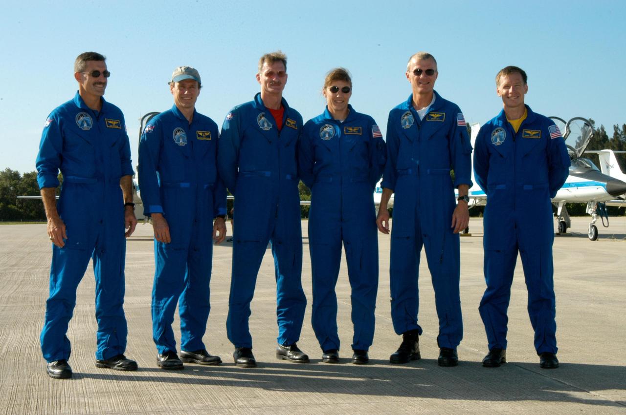KENNEDY SPACE CENTER, FLA. - After their arrival at KSC's Shuttle Landing Facility, the STS-115 crew poses for a photo after talking to the media.  From left are Mission Specialists Daniel Burbank, Steven MacLean, Joseph Tanner and Heidemarie Stefanyshyn-Piper; Commander Brent Jett; and Pilot Christopher Ferguson.  The STS-115 crew has flown to NASA's Kennedy Space Center to take part in Terminal Countdown Demonstration Test activities.  The TCDT is a pre-launch preparation that includes practicing emergency egress from the pad, driving an M-113 armored personnel carrier, and simulating the launch countdown. Launch of STS-115 is currently scheduled for Aug. 27.  Photo credit: NASA/George Shelton
