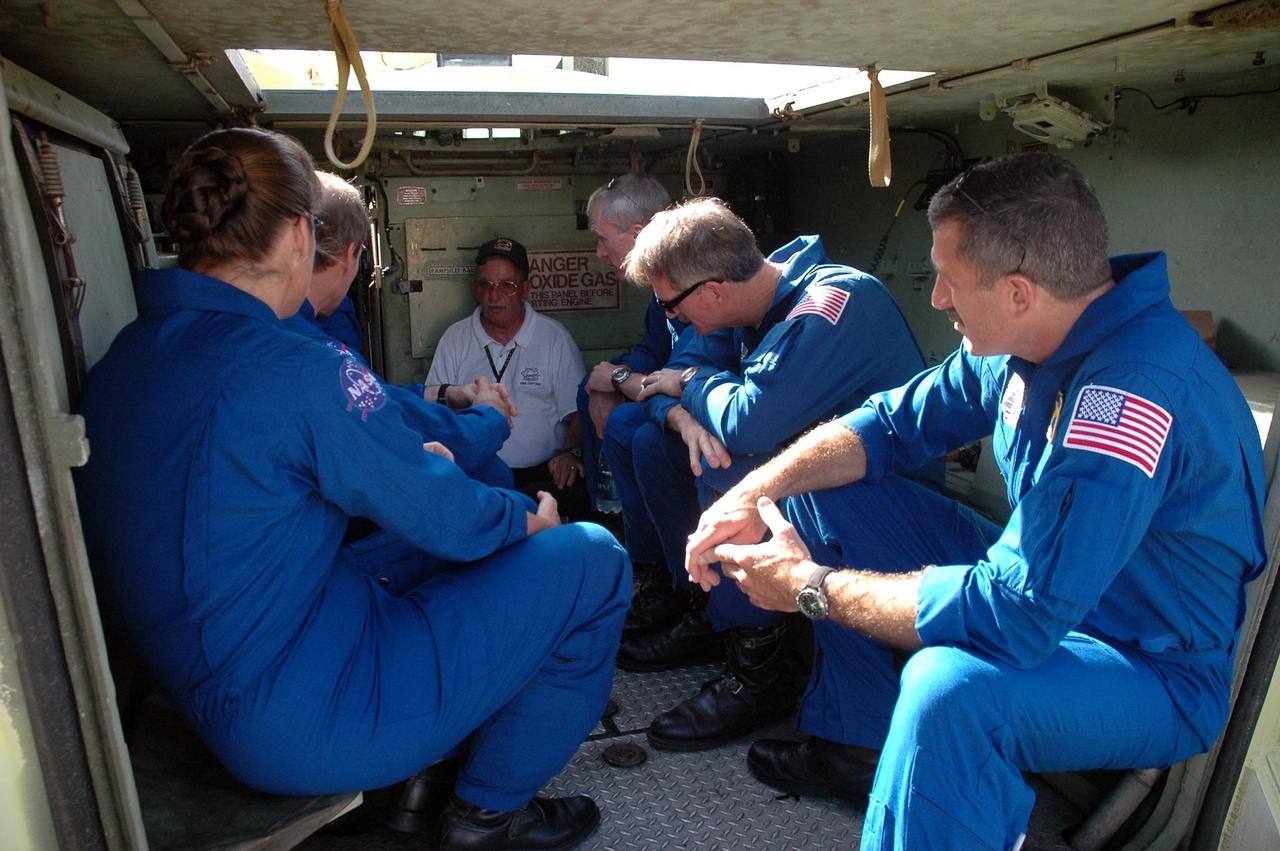 KENNEDY SPACE CENTER, FLA. -  Sitting inside the M-113 armored personnel carrier, the STS-115 crew members get instructions from Capt. George Hoggard, who is astronaut rescue team leader.  The astronauts at left are Mission Specialist Heidemarie Stefanyshyn-Piper and Pilot Christopher Ferguson.    At right are Commander Brent Jett and Mission Specialists Joseph Tanner and Daniel Burbank.  Not seen is Mission Specialist Steven MacLean, who represents the Canadian Space Agency.  The STS-115 crew are at NASA's Kennedy Space Center for Terminal Countdown Demonstration Test activities such as the M-113 training.  They will also practice emergency egress from the launch pad and take part in a simulated launch countdown.  Liftoff of mission STS-115 aboard Space Shuttle Atlantis is scheduled in a window beginning Aug. 27.   Photo credit: NASA/Cory Huston