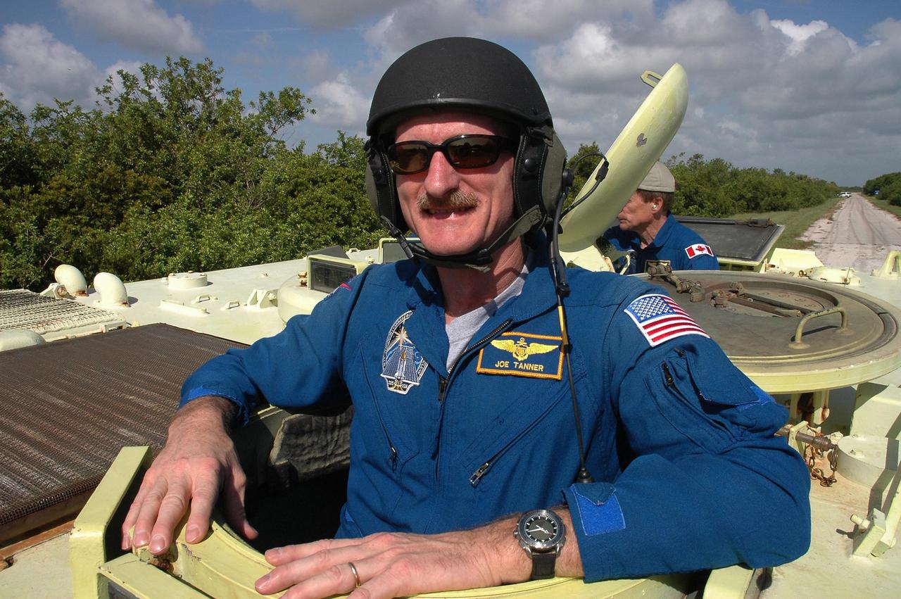 KENNEDY SPACE CENTER, FLA. - STS-115 Mission Specialist Joseph Tanner is ready to practice driving the M-113 armored personnel carrier. Behind him is seen Mission Specialist Steven MacLean, who represents the Canadian Space Agency. The STS-115 crew are at NASA's Kennedy Space Center for Terminal Countdown Demonstration Test activities such as the M-113 training. They will also practice emergency egress from the launch pad and take part in a simulated launch countdown. Liftoff of mission STS-115 aboard Space Shuttle Atlantis is scheduled in a window beginning Aug. 27. Photo credit: NASA/Cory Huston