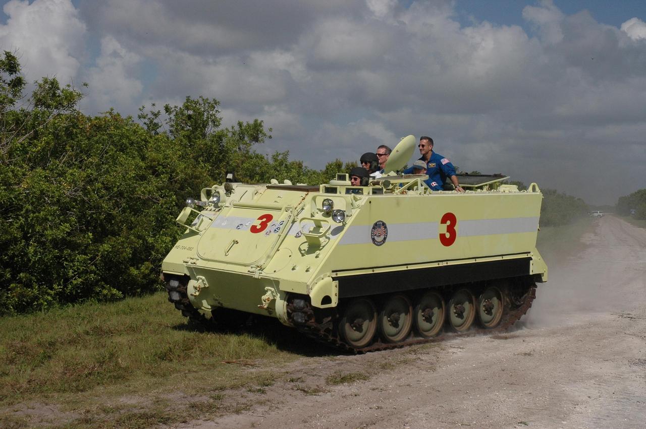 KENNEDY SPACE CENTER, FLA. -  STS-115 Commander Brent Jett takes his turn at the wheel, driving the M-113 armored personnel carrier.  Also on the ride are (left to right) Capt. George Hoggard, who is astronaut rescue team leader, and Mission Specialists Joseph Tanner, Steven MacLean and Daniel Burbank. The STS-115 crew are at NASA's Kennedy Space Center for Terminal Countdown Demonstration Test activities such as the M-113 training.  They will also practice emergency egress from the launch pad and take part in a simulated launch countdown.  Liftoff of mission STS-115 aboard Space Shuttle Atlantis is scheduled in a window beginning Aug. 27.   Photo credit: NASA/Cory Huston