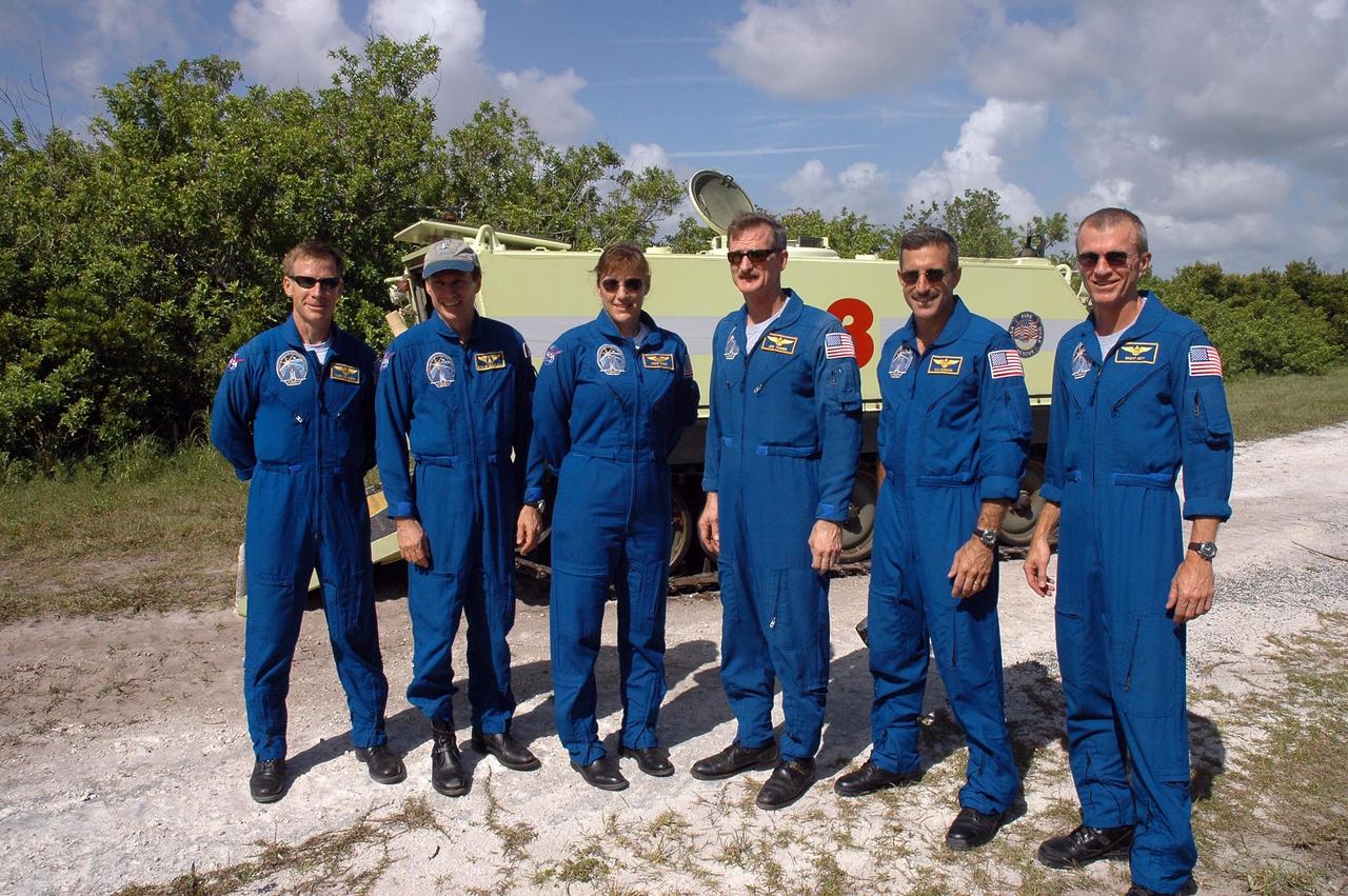 KENNEDY SPACE CENTER, FLA. -  After successfully completing their driving practice on the M-113 armored personnel carrier behind them, the STS-115 crew poses for a photo.  From left are Pilot Christopher Ferguson, Mission Specialists Steven MacLean, Heidemarie Stefanyshyn-Piper, Joseph Tanner and Daniel Burbank, and Commander Brent Jett.  The STS-115 crew are at NASA's Kennedy Space Center for Terminal Countdown Demonstration Test activities such as the M-113 training.  They will also practice emergency egress from the launch pad and take part in a simulated launch countdown.  Liftoff of mission STS-115 aboard Space Shuttle Atlantis is scheduled in a window beginning Aug. 27.   Photo credit: NASA/Cory Huston